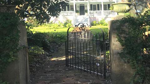 The Quiet Elegance of Beaufort- Brick Walkways, Garden Gates, and Hidden Gardens. a wrought iron gate opened